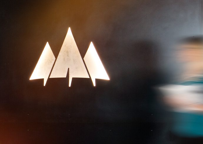 A person walking down a hallway past the Laird Norton Company logo.