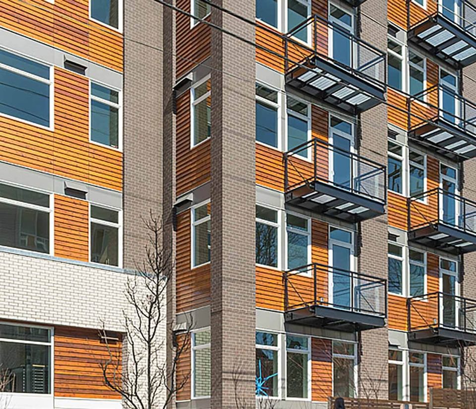 Street view of a multi-story building with balconies.